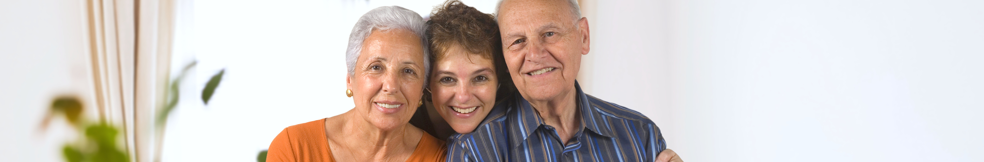 caregiver and elderly couple smiling